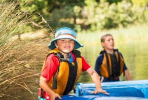Smiling child walking out from the water of Cave Hill Creek