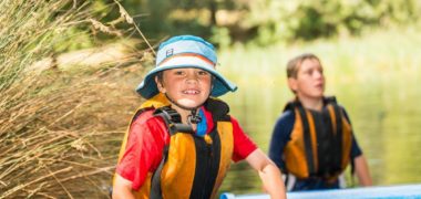 Smiling child walking out from the water of Cave Hill Creek