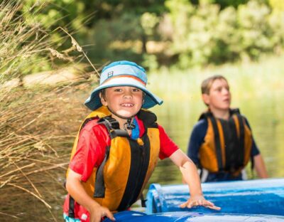 Smiling child walking out from the water of Cave Hill Creek