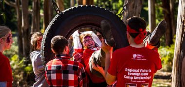 Regional Victoria Bendigo Bank Camp Awakenings group activity featuring person being helped through a suspended tyre