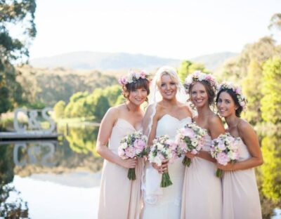 group photo of bride and bridesmaids with cave hill creek and hills in background