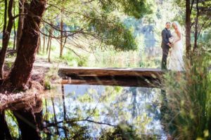 Wedding photo of couple standing next to Cave Hill Creek