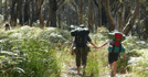 Image of two people with hiking bags walking in the bush