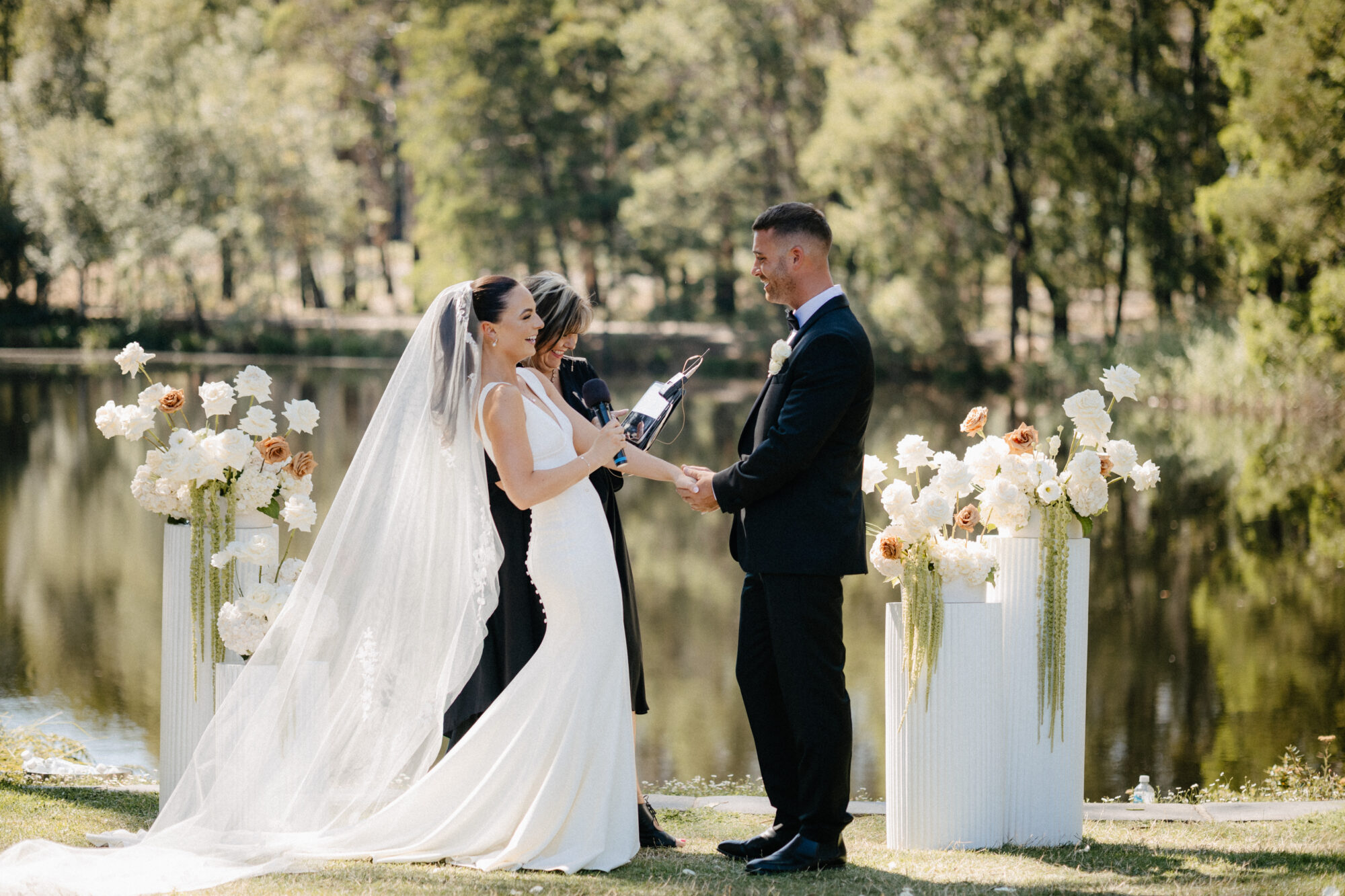 Bride and groom saying their vows at a wedding ceremony overlooking a lake