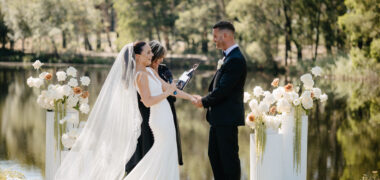 Bride and groom saying their vows at a wedding ceremony overlooking a lake