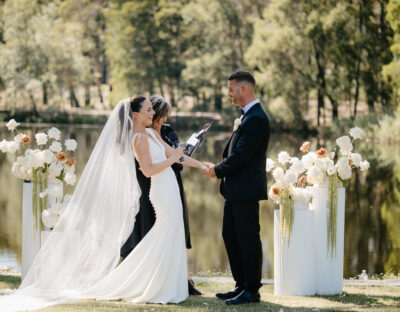 Bride and groom saying their vows at a wedding ceremony overlooking a lake