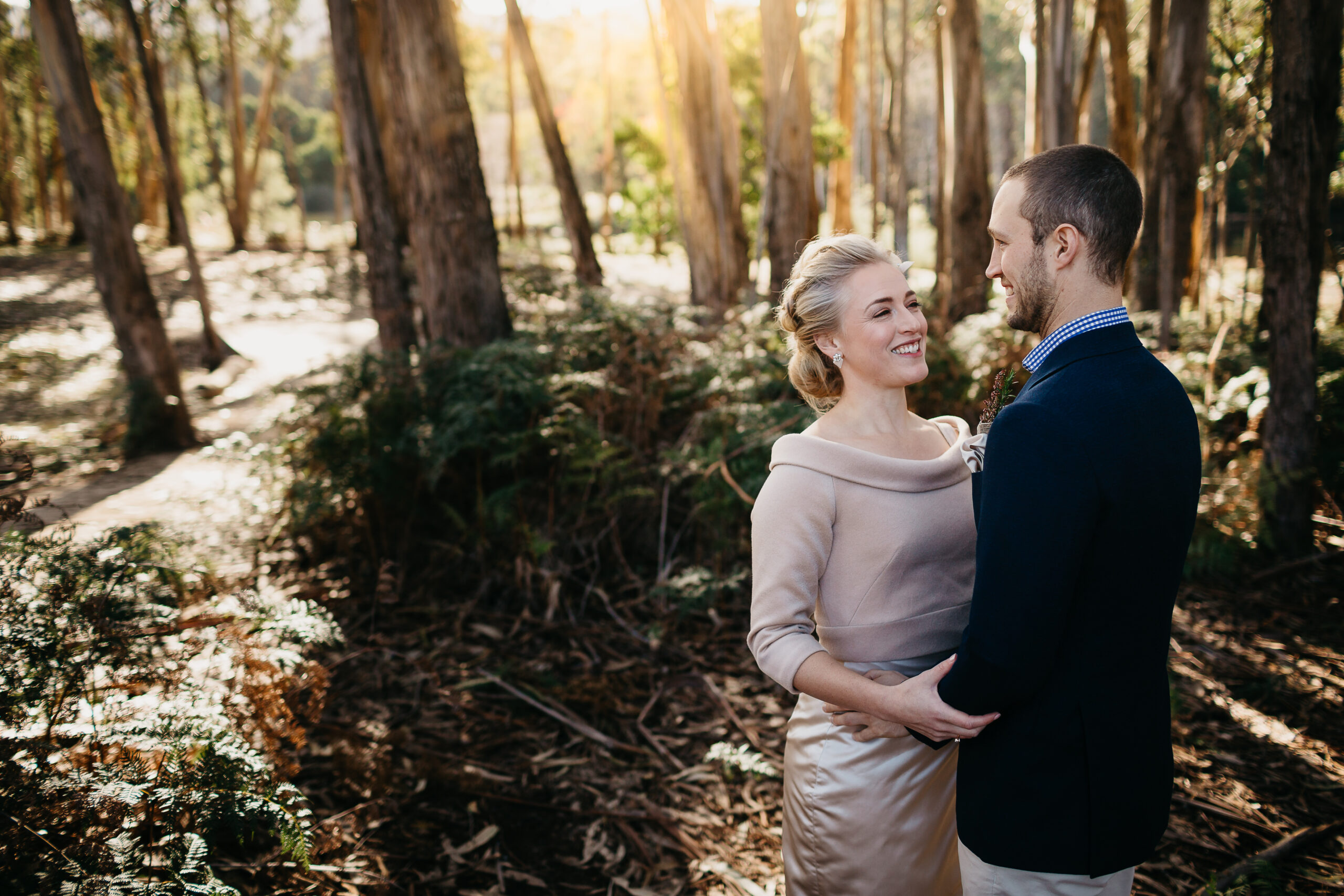 Couple standing among gum trees at Cave Hill Creek in winter light